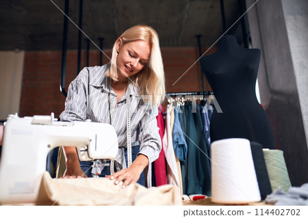 young designer concentrated on making clothing 114402702