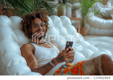 Man Sitting in Chair With Cell Phone Man Sitting in Chair With Cell Phone 114402804