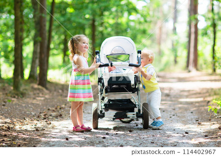 Children pushing stroller with newborn baby 114402967