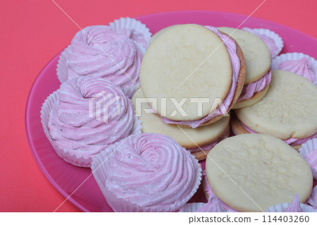 Cooked marshmallow sandwiches. They lie on plate. Next on the plate is a marshmallow of various sizes. Cooked marshmallow sandwiches. They lie on plate. Next on the plate is a marshmallow of various sizes. 114403260