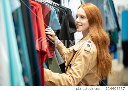 Beautiful redhaired woman in search of clothes 114403337