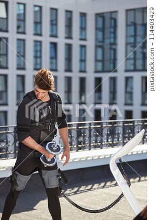 handsome ambitious bodyduilder in EMS suit handsome ambitious bodyduilder in EMS suit 114403429
