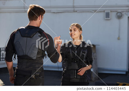 team workout concept. blond girl is thanking her personal coach for workout team workout concept. blond girl is thanking her personal coach for workout 114403445