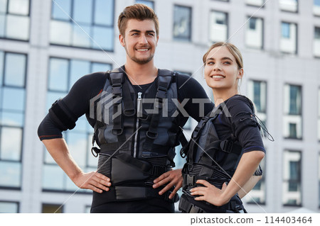 two pleasant people are happy because they have tested new EMS suits for the first time two pleasant people are happy because they have tested new EMS suits for the first time 114403464