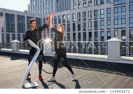 positive man and woman wearing EMS costumes are rejoycing at good results positive man and woman wearing EMS costumes are rejoycing at good results 114403472