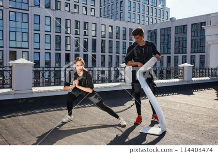 fair-haired fit girl is working out with personal trainer 114403474