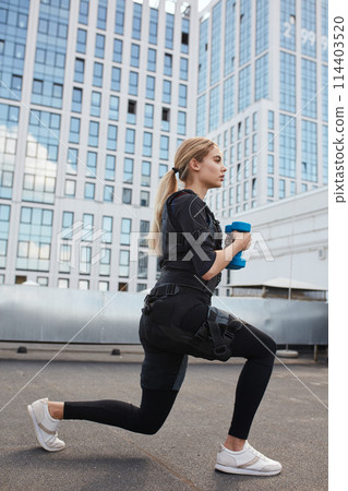 beautiful sporty woman squatting while workout 114403520