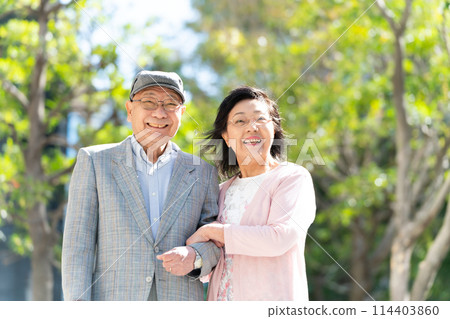 拄著綠色拐杖行走的老夫婦 114403860