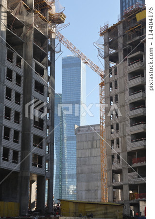 Construction site with cranes against the sky. Construction machinery, construction of skyscrapers. 114404176