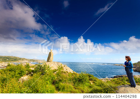 Woman tourist looking at ocean in Norway Woman tourist looking at ocean in Norway 114404298