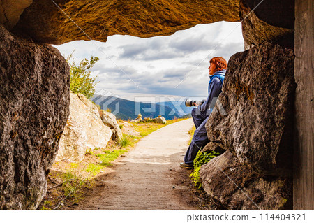 Tourist on Vedahaugane cave entrance, Norway Tourist on Vedahaugane cave entrance, Norway 114404321