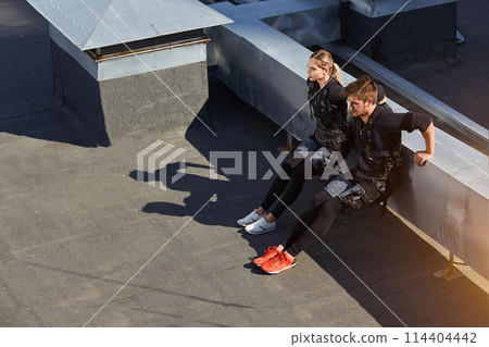 two athletes are performing knee bends 114404442