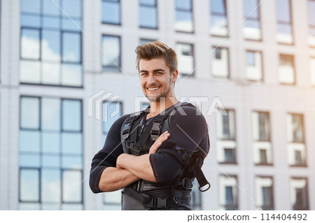 positive cheerful well-built man standing with crossed amrs and looking at the camera positive cheerful well-built man standing with crossed amrs and looking at the camera 114404492