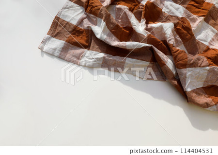 Overhead shot of rusty brown checkered table cloth isolated on white background with copyspace. Wrinkled gingham tea towel, textile napkin. Restaurant Bavarian banner. Flat lay, top view Festa junina, Overhead shot of rusty brown checkered table cloth isolated on white background with copyspace. Wrinkled gingham tea towel, textile napkin. Restaurant Bavarian banner. Flat lay, top view Festa junina, 114404531