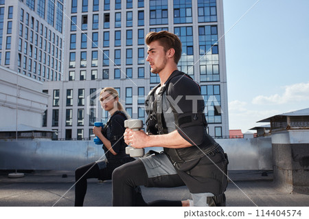 male personal trainer is working out with a female client 114404574