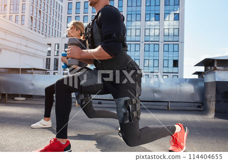 sporty man and woman is using EMS machine sporty man and woman is using EMS machine 114404655