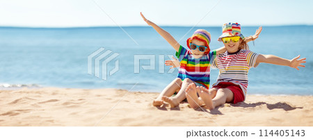 Happy children sitting on the sand beach in sunny day. 114405143
