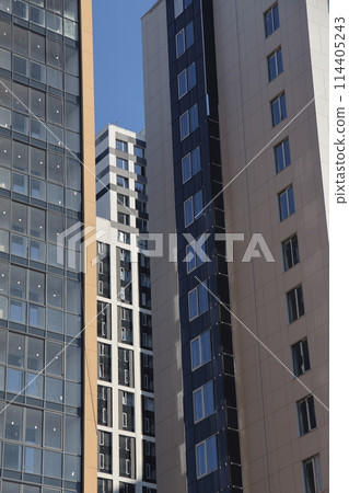 Futuristic design part of skyscrapers against a clear blue sky. Abstract facade design. 114405243