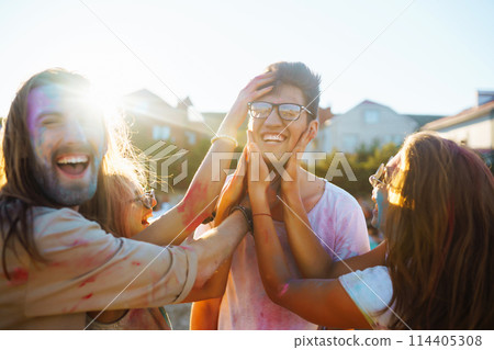 A group of friends have fun, dance at the holi festival. Spring Beach Party. Friendship, Leisure, Togetherness. 114405308