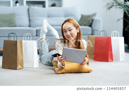 Happy Young Woman Shopping Online With Tablet At Home Happy Young Woman Shopping Online With Tablet At Home 114405857