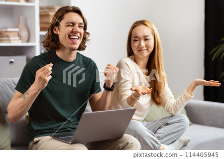 Happy Couple Celebrating Success With Laptop At Home Happy Couple Celebrating Success With Laptop At Home 114405945