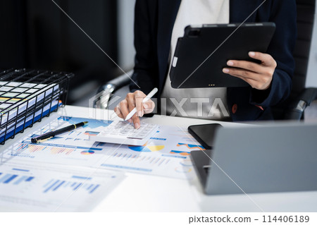Business woman using a tablet and computer to analysis graph company financial with colleagues at office. Business woman using a tablet and computer to analysis graph company financial with colleagues at office. 114406189