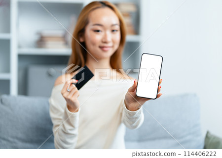Young Woman Displaying Smartphone And Credit Card Indoors 114406222
