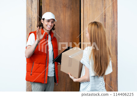 Courier Delivering Parcel to Young Woman at home Courier Delivering Parcel to Young Woman at home 114406225