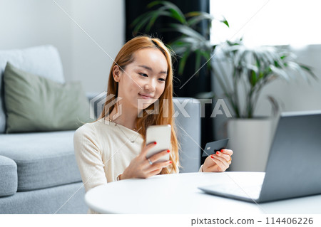 Young Asian Woman Shopping Online on Laptop at Home Young Asian Woman Shopping Online on Laptop at Home 114406226