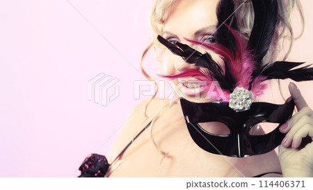 Woman middle aged holds carnival mask. 114406371