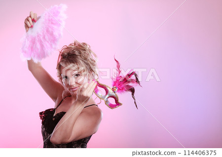 Woman holding carnival mask feather fan in hand Woman holding carnival mask feather fan in hand 114406375