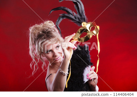 Woman holding carnival mask feather fan in hand 114406404