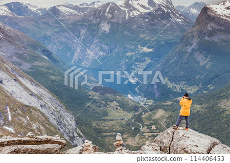 Tourist taking photo from Dalsnibba viewpoint Norway 114406453