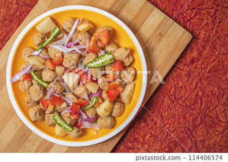 Ready to cook healthy food meal maker curry. Potatoes, onions, tomatoes, green chillies on yellow plate. 114406574