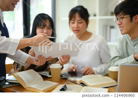 Senior professor explaining something to students during class at university 114406960