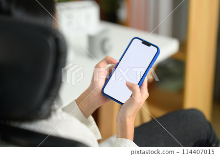 Close up businesswoman holding mobile phone with empty screen sitting at office desk 114407015