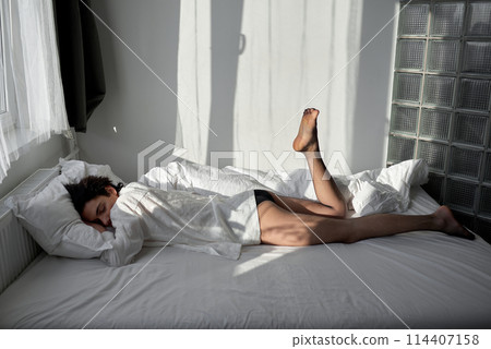 young handsome slim man sleeping on bed young handsome slim man sleeping on bed 114407158
