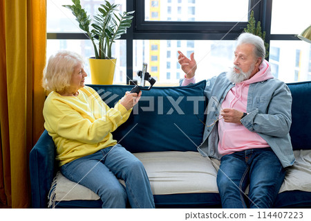 happy senior couple with smartphone making selfie, taking photo and video on smartphone happy senior couple with smartphone making selfie, taking photo and video on smartphone 114407223
