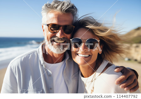 Summer portrait happy smiling mature couple together on sunny coast, enjoying beach vacation at sea 114407792