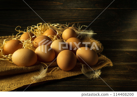 Full chicken nest with eggs. An egg is a healthy food for lunch. Place for advertising on a dark background 114408200