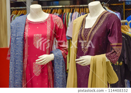 Set of saris displayed on different family mannequins at luxury shop, New Delhi 114408332