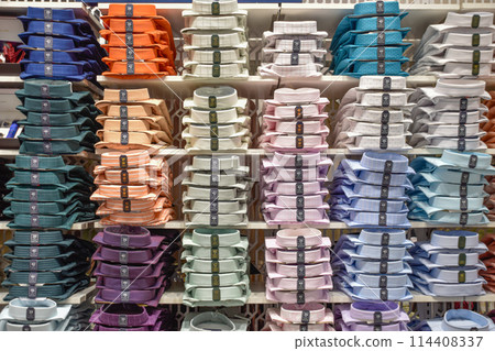 Set of shirts in different colors stacked in store. Textile trade and commerce. 114408337