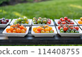 A variety of small tomatoes are displayed on a wooden table. 114408755