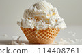 A white ice cream sundae in a waffle cup, topped with coconut flakes, on a plain white background. 114408761