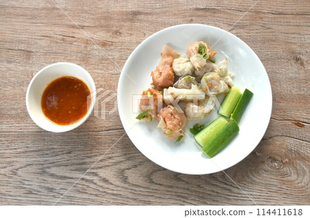 steamed fish and shrimp dumpling topping crispy  fried chop garlic with cucumber on plate dipping spicy and sour sauce cup 114411618
