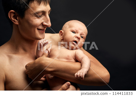 own child. amiable baby in father's arms 114411833