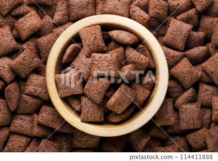 Chocolate corn pads in a wooden plate background. Top view 114411888