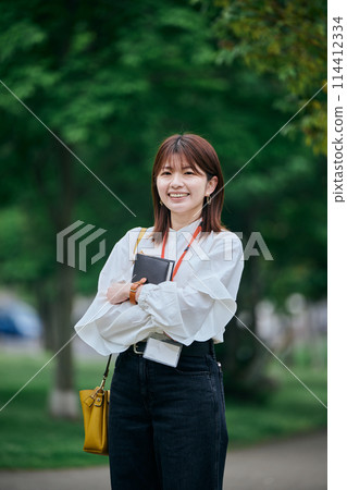 拿著筆記本微笑的年輕女子 拿著筆記本微笑的年輕女子 114412334