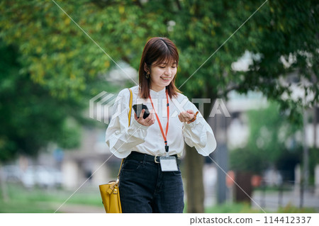 年輕女子邊走邊看時鐘 114412337