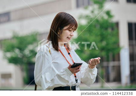 年輕女子邊走邊看時鐘 年輕女子邊走邊看時鐘 114412338